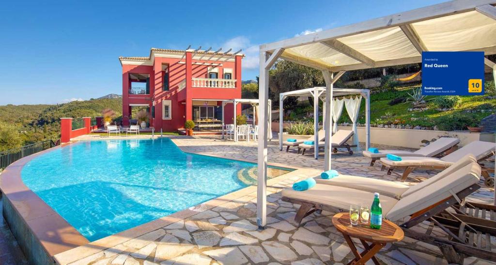 a swimming pool with chairs and a house at Red Queen in Sfakerá