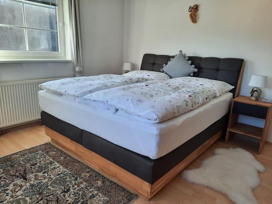 ein Bett in einem Schlafzimmer mit einer schwarzen und weißen Matratze in der Unterkunft Wohnen in Graz Mariatrost in Graz