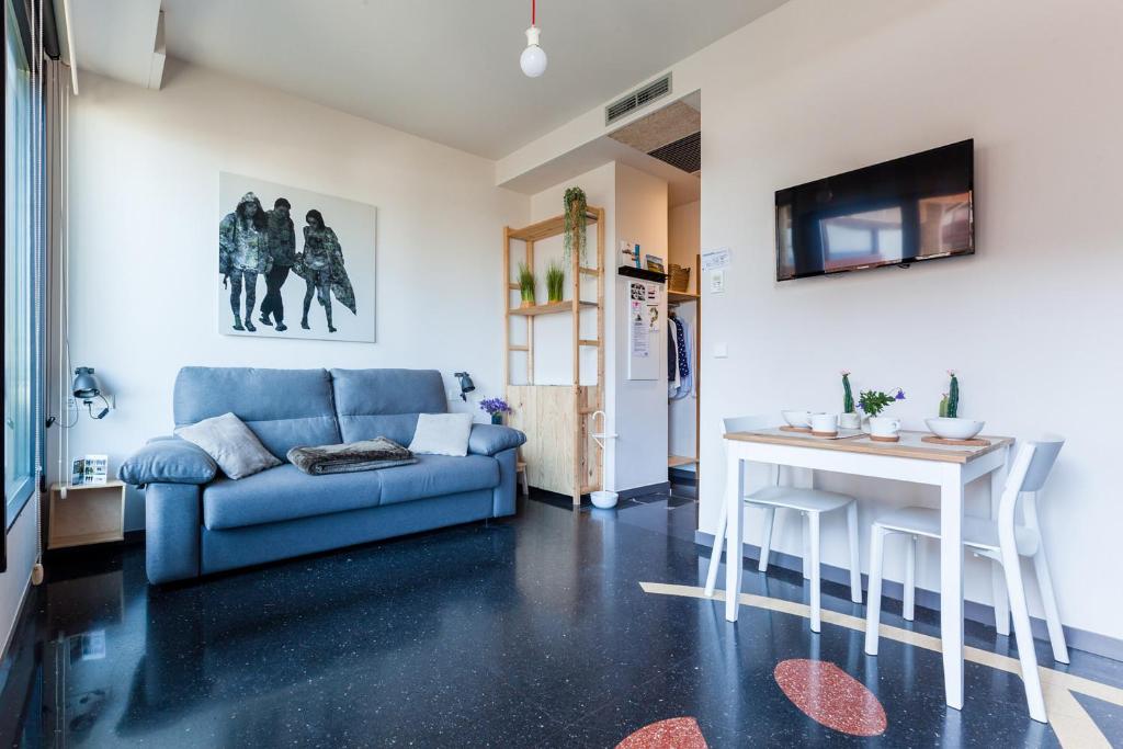 sala de estar con sofá azul y mesa en Apartamentos Dada, en Zarautz