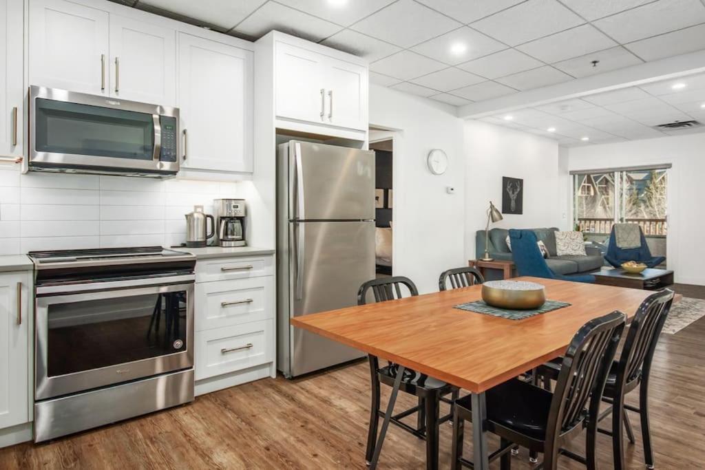 een keuken en eetkamer met een tafel en een koelkast bij Mountain Modern Hideaway in Canmore