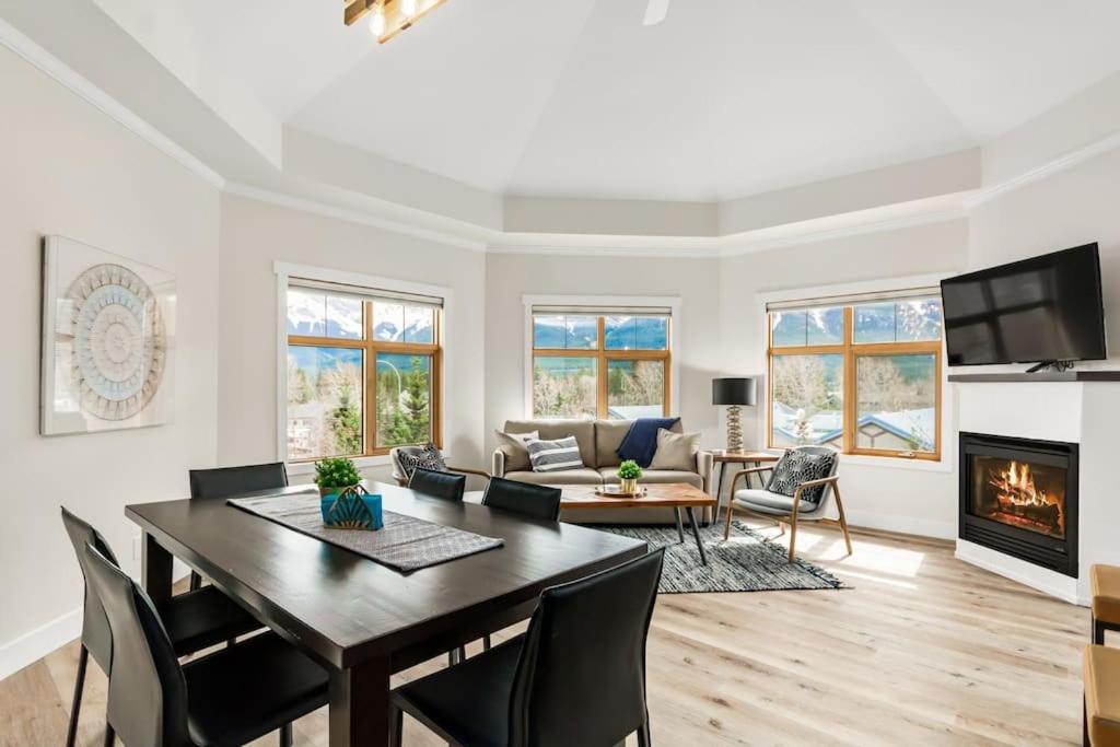a living room with a dining table and a fireplace at The Grand Escape Downtown Canmore in Canmore