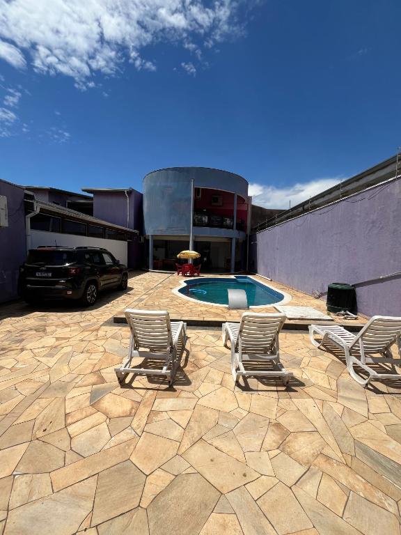 a patio with chairs and a swimming pool at Pousada Azul Ms in Viracopos