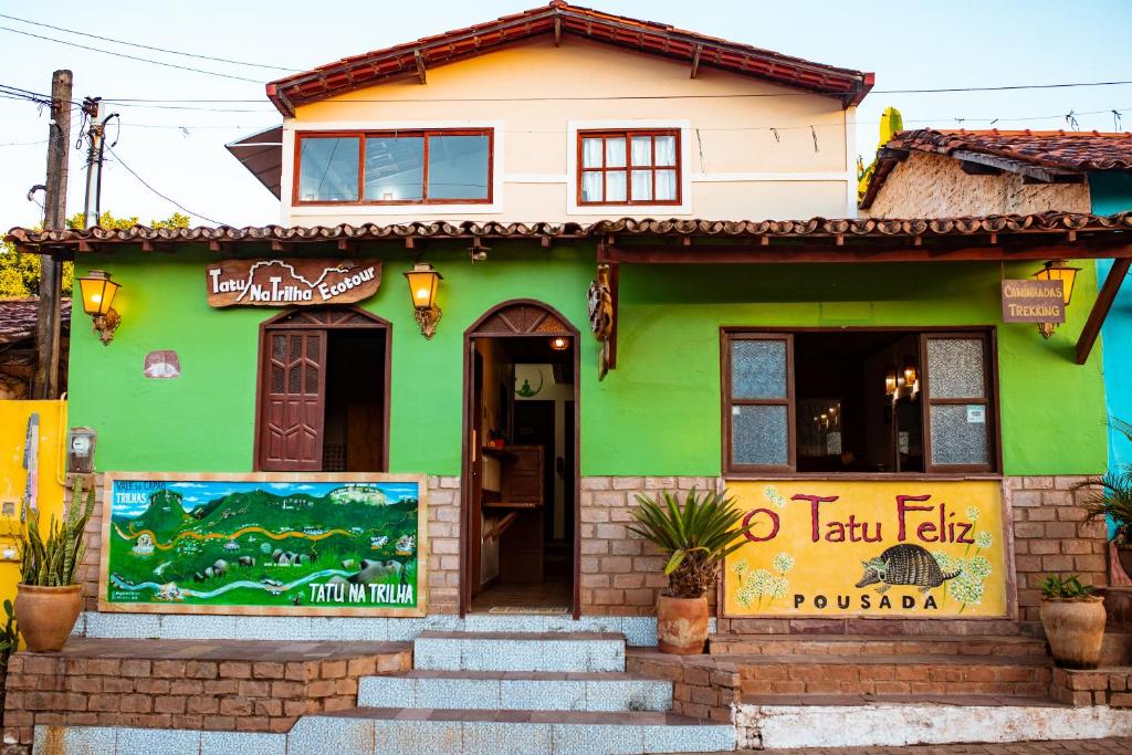 a green building with stairs in front of it at Pousada Tatu Feliz in Vale do Capao