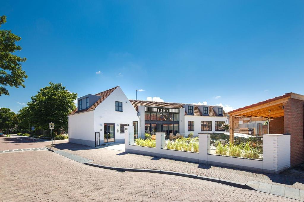 una casa con jardín frente a una calle en Hotel Blooker en Renesse