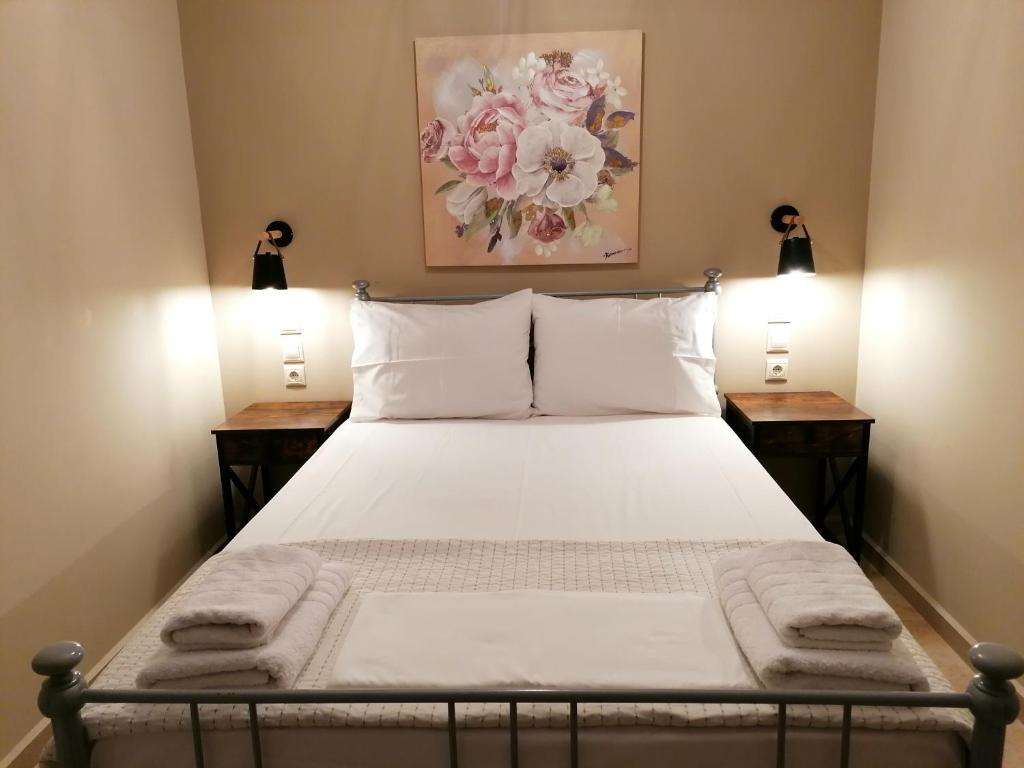 ein Schlafzimmer mit einem Bett mit zwei Nachttischen in der Unterkunft Marinos Studios - 2nd floor studio in Póros