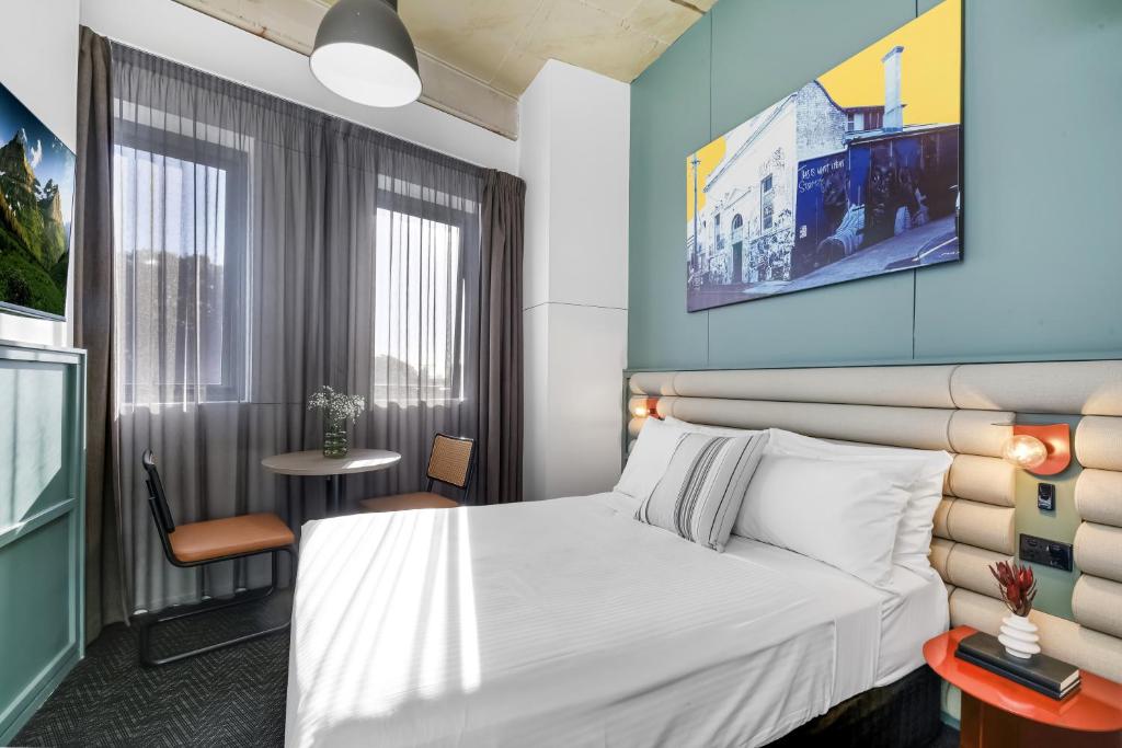a hotel room with a bed and a table at The Urban Newtown in Sydney