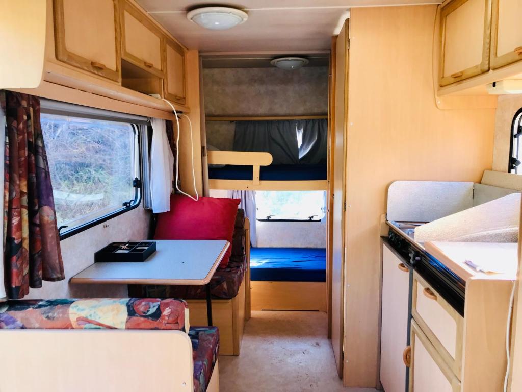 an interior view of an rv with a kitchen and a table at La caravane de la tuilerie in Seix