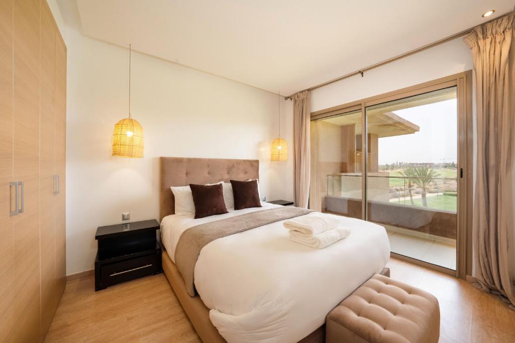 sypialnia z dużym łóżkiem i dużym oknem w obiekcie Vue Imprenable golf-Piscine w Marakeszu