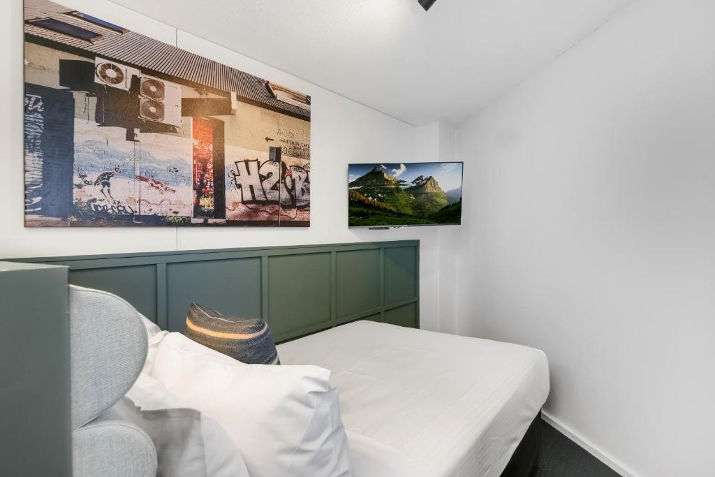 a room with a bed and posters on the wall at The Urban Newtown in Sydney