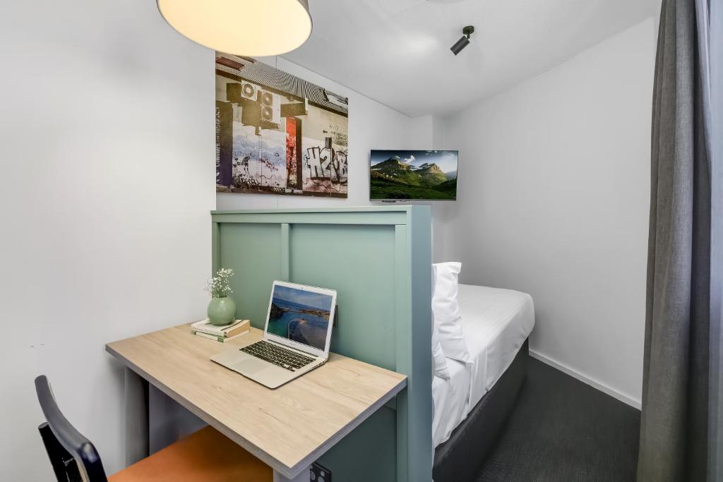 a small room with a desk with a laptop on it at The Urban Newtown in Sydney