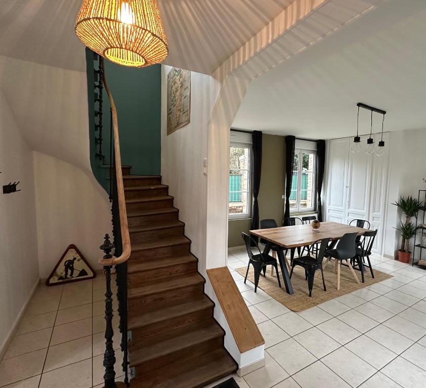 een trap in een huis met een tafel en een eetkamer bij Charmante Maison de 3 Ch avec Jardin et Parking 