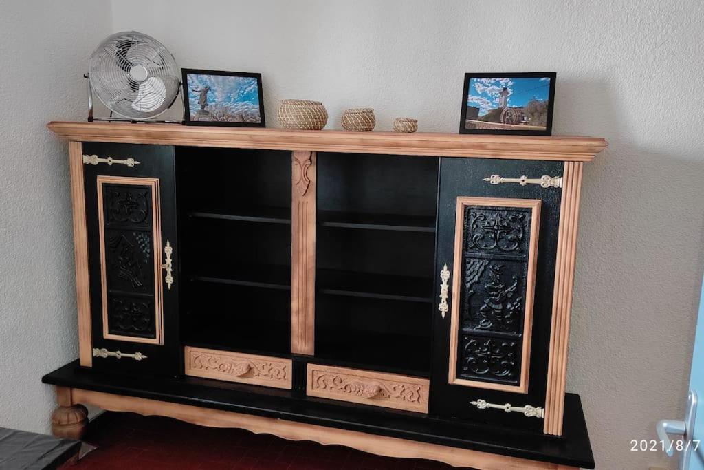 a black cabinet with two doors and two pictures on it at Charmant appartement T2 de 36m² au cœur du village in Saintes-Maries-de-la-Mer