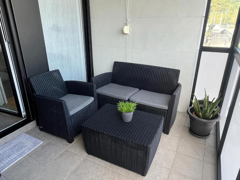 2 sillas de mimbre y una mesa en el balcón en Apartamento moderno y acogedor ideal familias, en Orio