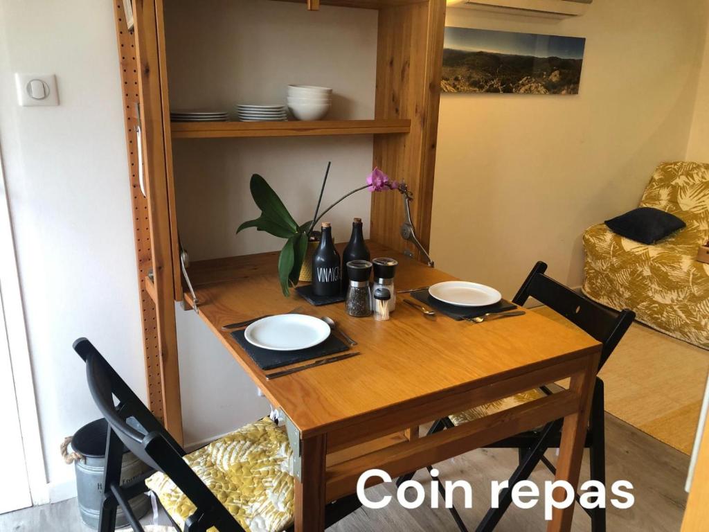 a dining room table with two chairs and a table at Pause au pied des Cevennes in Alès