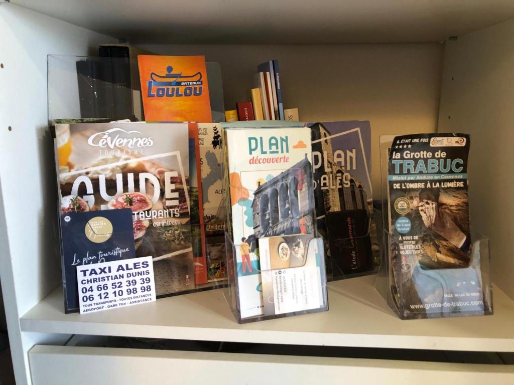 a shelf with books and games on it at Pause au pied des Cevennes in Alès