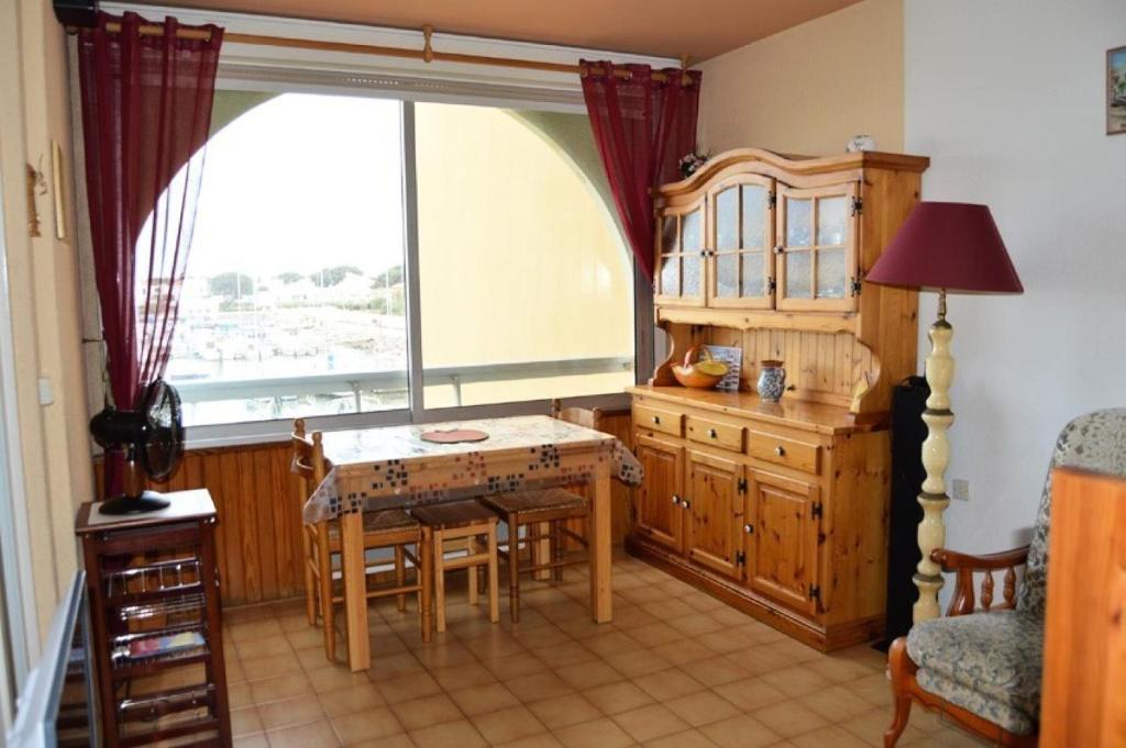 une salle à manger avec une table et une fenêtre dans l'établissement Résidence Le Cezelly - 2 Pièces 4 couchages PORT LEUCATE MAE-6334, à Port-Leucate