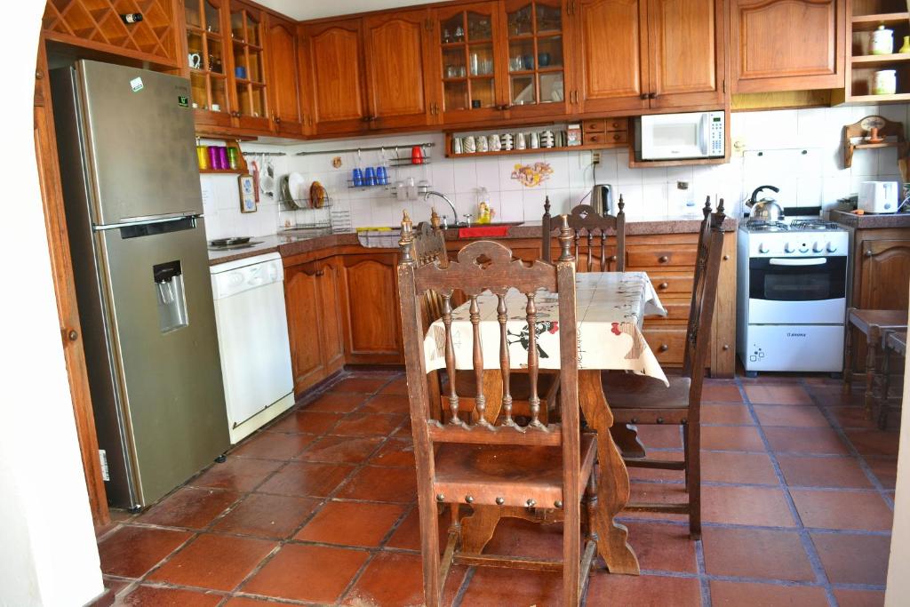 a kitchen with a table and a refrigerator at Posada Santa Rita in Colonia del Sacramento