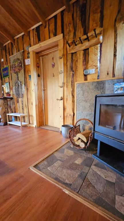 ein Wohnzimmer mit einem TV und Holzböden in der Unterkunft Cabaña en Valdivia in Valdivia