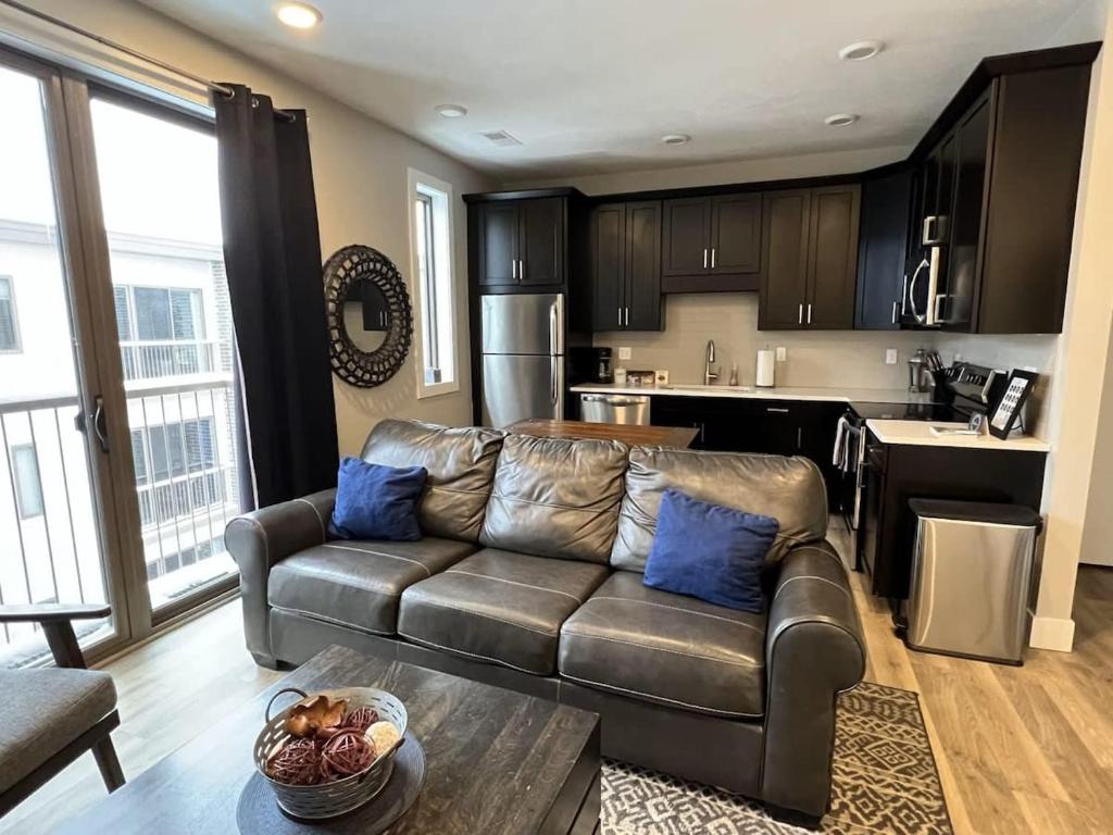 a living room with a leather couch and a kitchen at Trendy Downtown Condo-Walk to it ALL Capri 315 in Traverse City