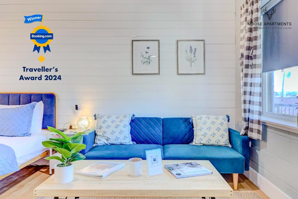 Sofá azul en la sala de estar con mesa en The Moose #8 - Modern Luxe Loft with King Bed & Free Parking & Wifi en Memphis