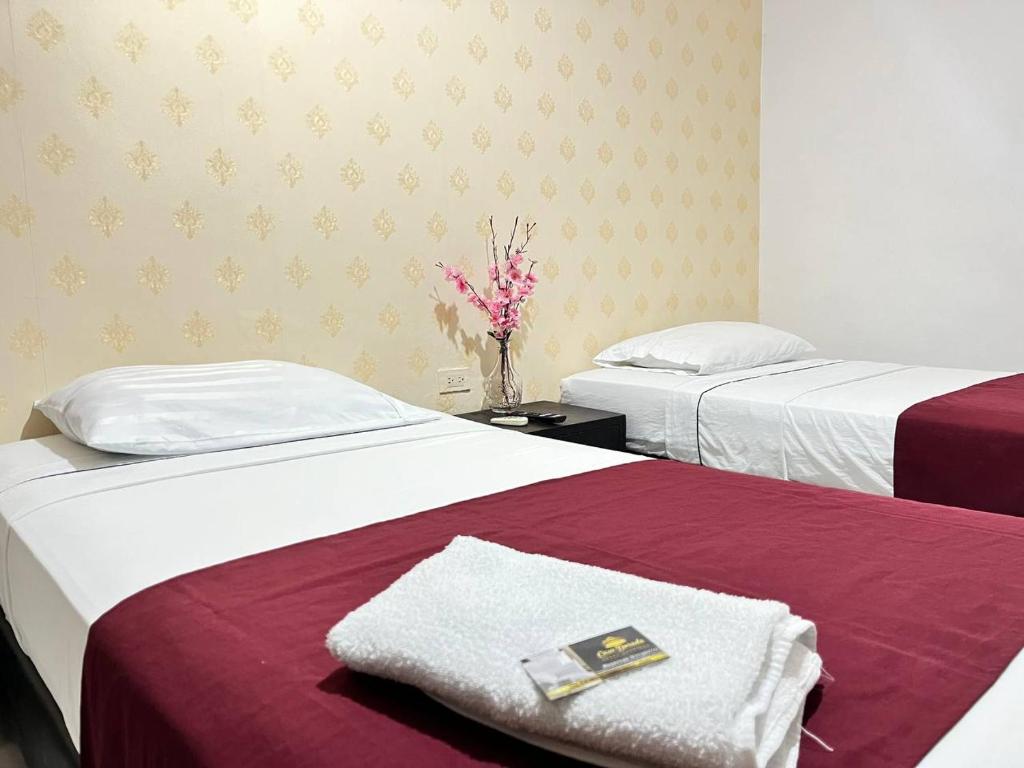 Hotel Boutique Casa Dorada في نيفا: غرفة في الفندق بسريرين و إناء من الزهور