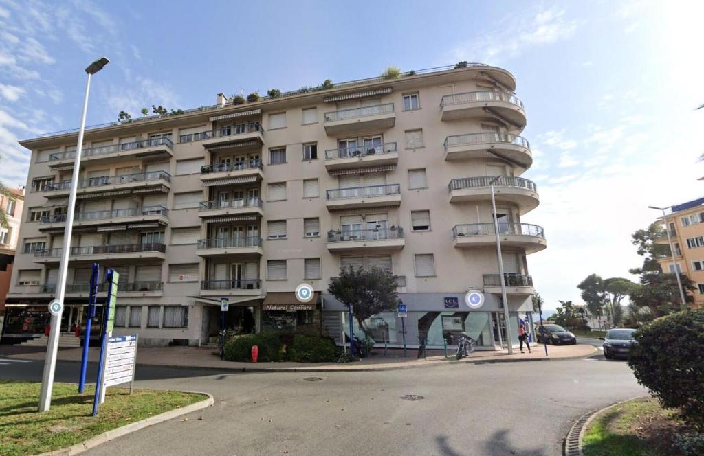 a large apartment building on the corner of a street at Résidence La Piscine - 3 Pièces pour 6 Personnes 261 in Menton