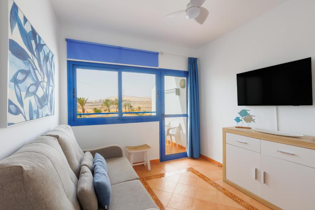 a living room with a couch and a large window at Astarita SUN in Costa Calma