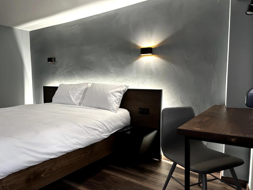 - une chambre avec un lit, un bureau et une table dans l'établissement Wooden Suites, à Thessalonique