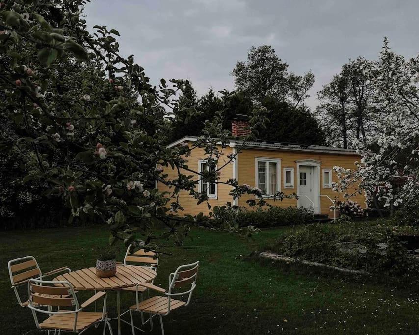 a table and chairs in front of a yellow house at Lillebo - Centralt mysigt hus i Nora in Nora