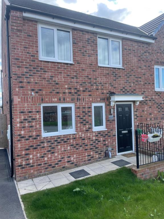 a red brick house with a black door at 2 bedroom house in Seacroft