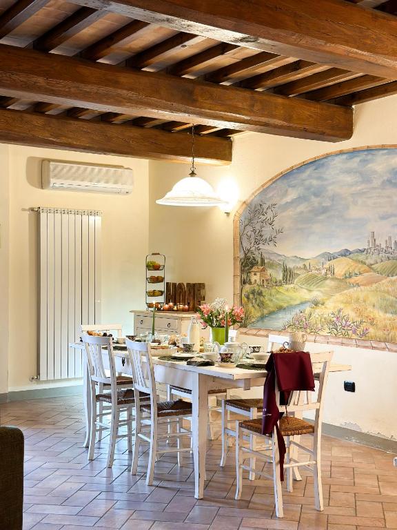 jadalnia z białym stołem i krzesłami w obiekcie Monolocale il vecchio fienile w mieście San Gimignano