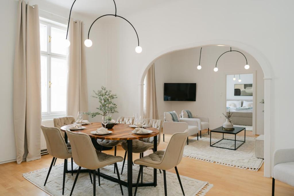 a dining room with a table and chairs and a living room at Stylish APT for 4-6 metro & walk 5 min to center in Vienna