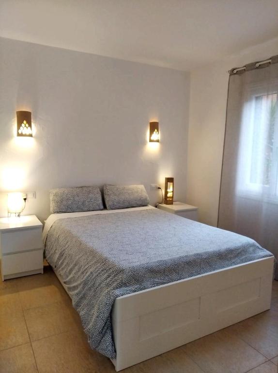 a bedroom with a large bed with two night stands at Es Niuet in Cala Galdana