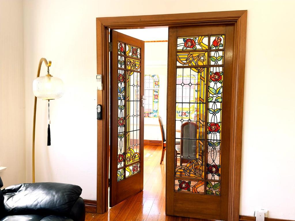 a room with a door with stained glass at Handcrafted stained-glass cottage, free parking in Hobart