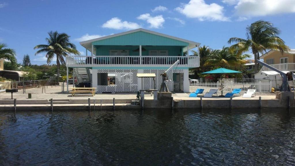 une maison sur un quai à côté d'une masse d'eau dans l'établissement Go Fish Inn, à Big Pine Key