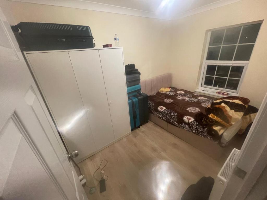 a small bedroom with a bed and a white cabinet at 11 Chalvey Road east sl12ll in Slough