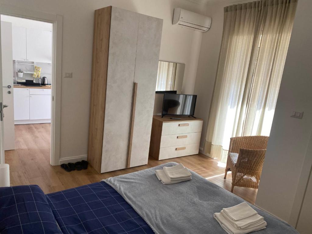 um quarto com uma cama, uma cómoda e uma televisão em CasaTua em Catânia