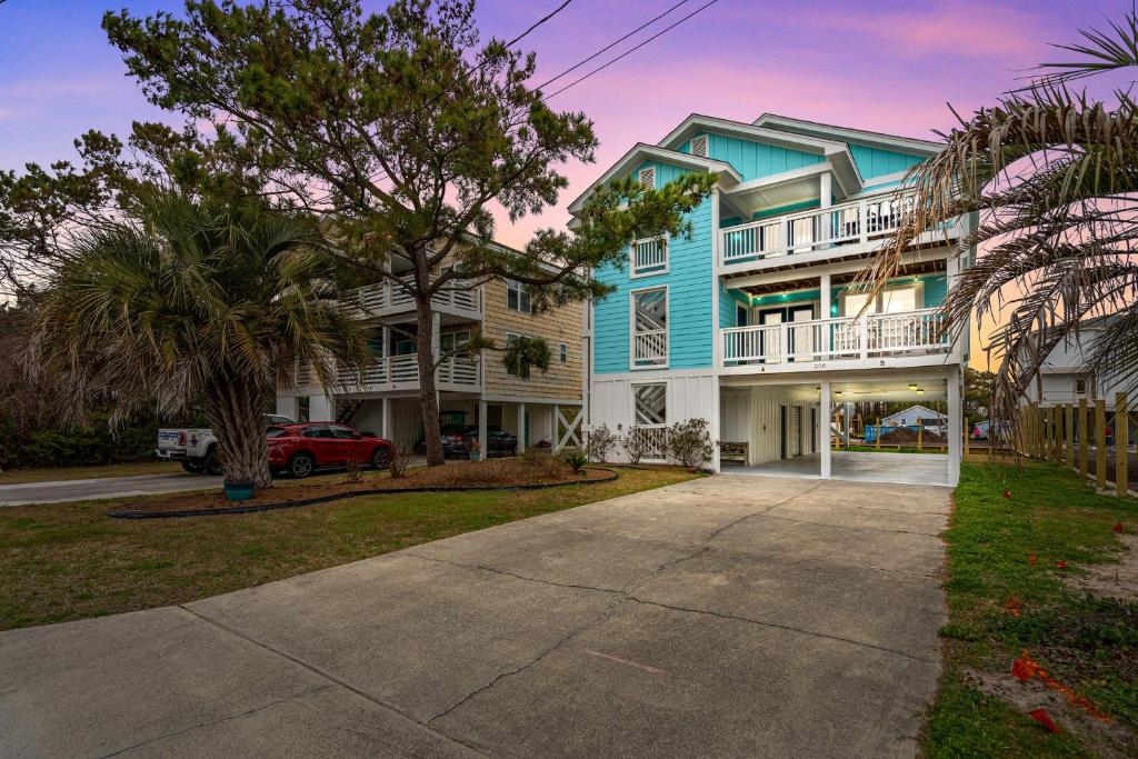 a blue and white house with a driveway at Golden Hour on Greenville- 1.5 blocks to beach, Pet Friendly, & No Hidden Fees!! in Carolina Beach