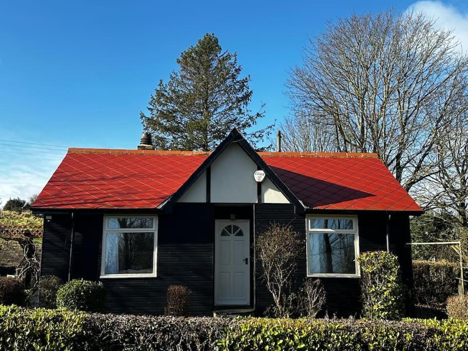 a small black house with a red roof at Sunnybank cottage in Alnwick