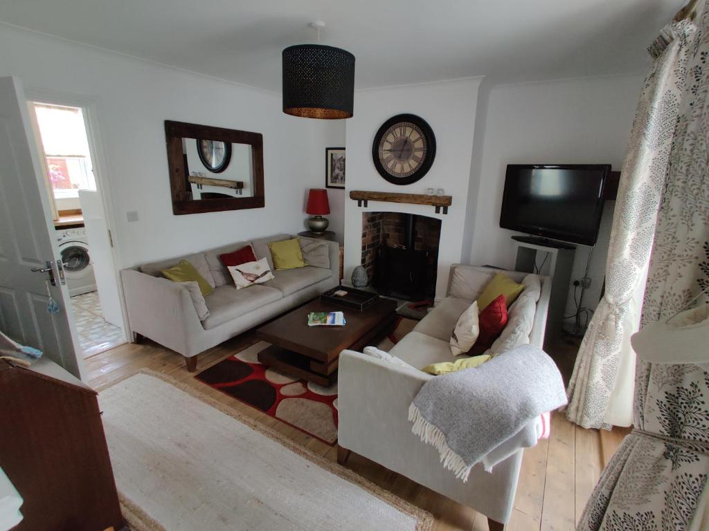 a living room with two couches and a fireplace at Rose Cottage, Newbiggin-by-the-Sea in Woodhorn