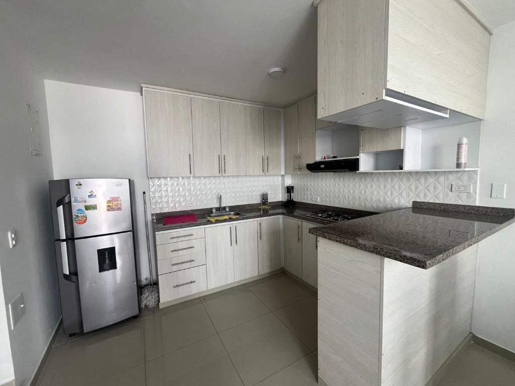 a kitchen with white cabinets and a white refrigerator at CASA AMOBLADA CERCA A LA BASILICA in Club del Comercio