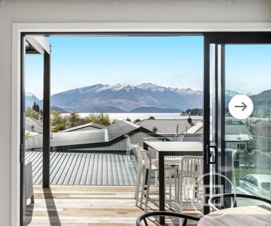 a balcony with a table and chairs and a view of the mountains at Super Central in Wanaka in Wanaka