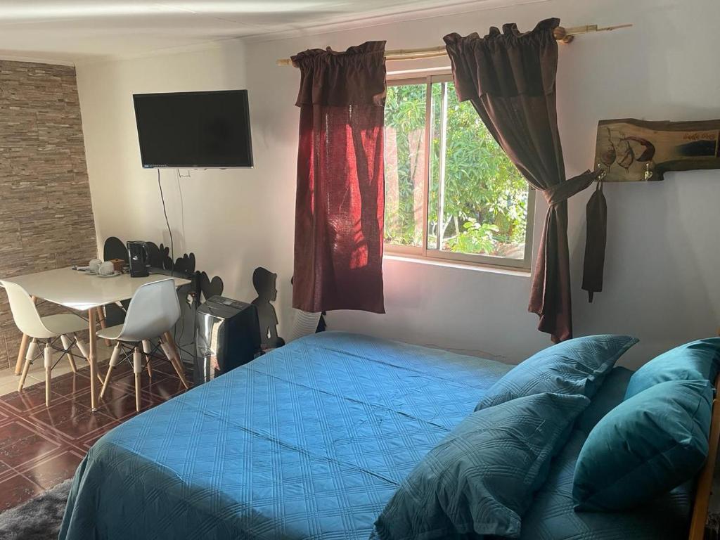 1 dormitorio con cama, mesa y ventana en Westside - Habitación con baño privado en Santa Cruz