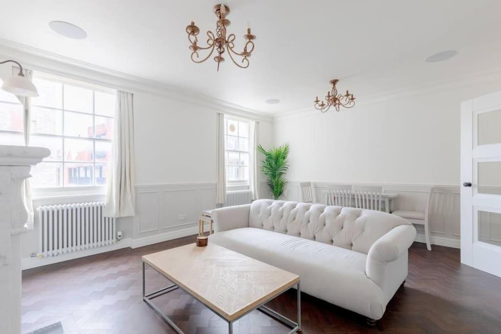 a living room with a white couch and a table at Elegant 3 Bed Flat in Marylebone, London in London