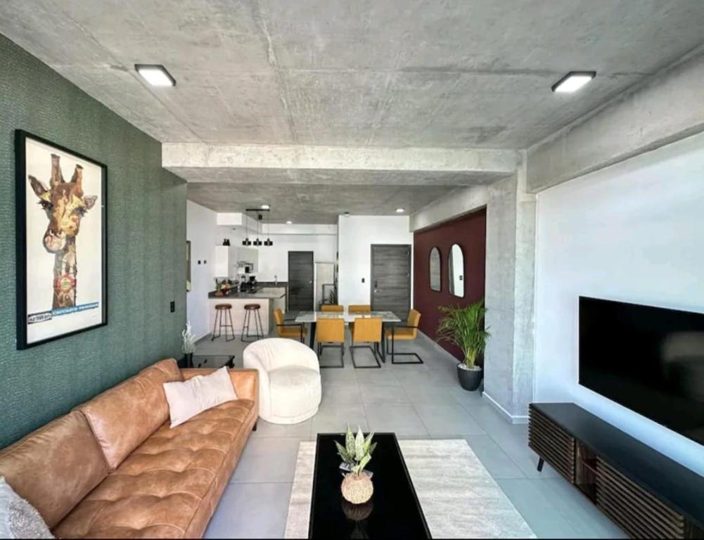 Spacious & Classy apartment in Santa Elena في Antiguo Cuscatlán: غرفة معيشة بها أريكة وتلفزيون