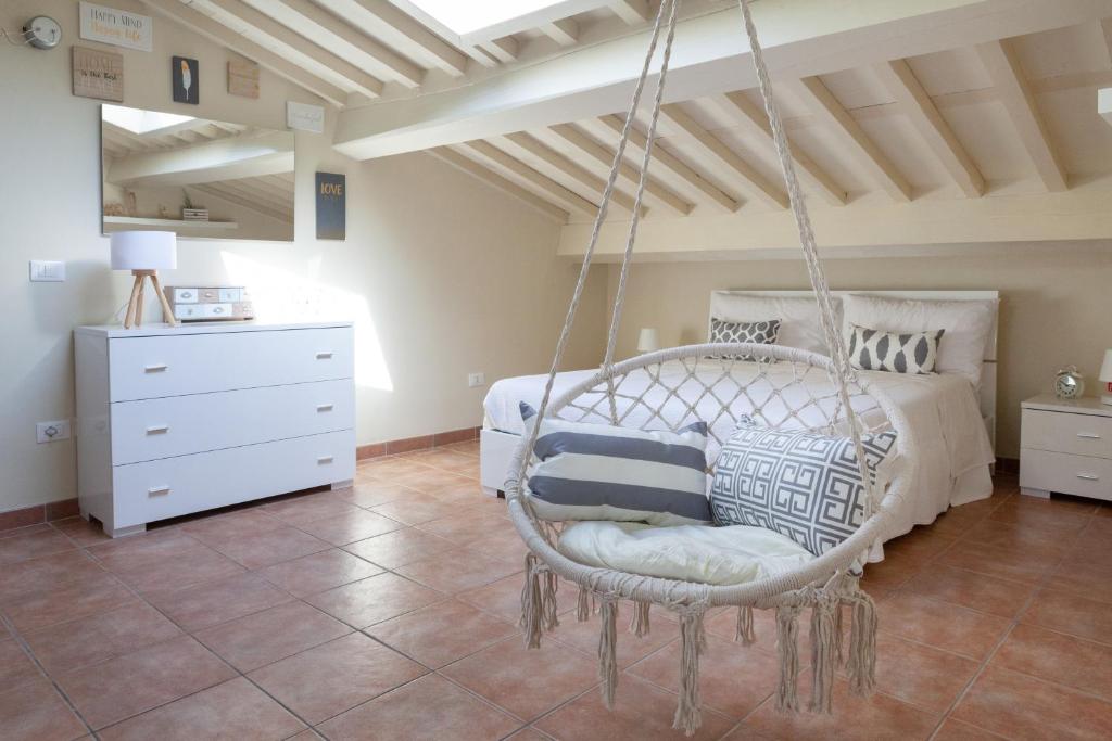 a bedroom with a swinging bed and a white dresser at White Attic Lucca in Lucca