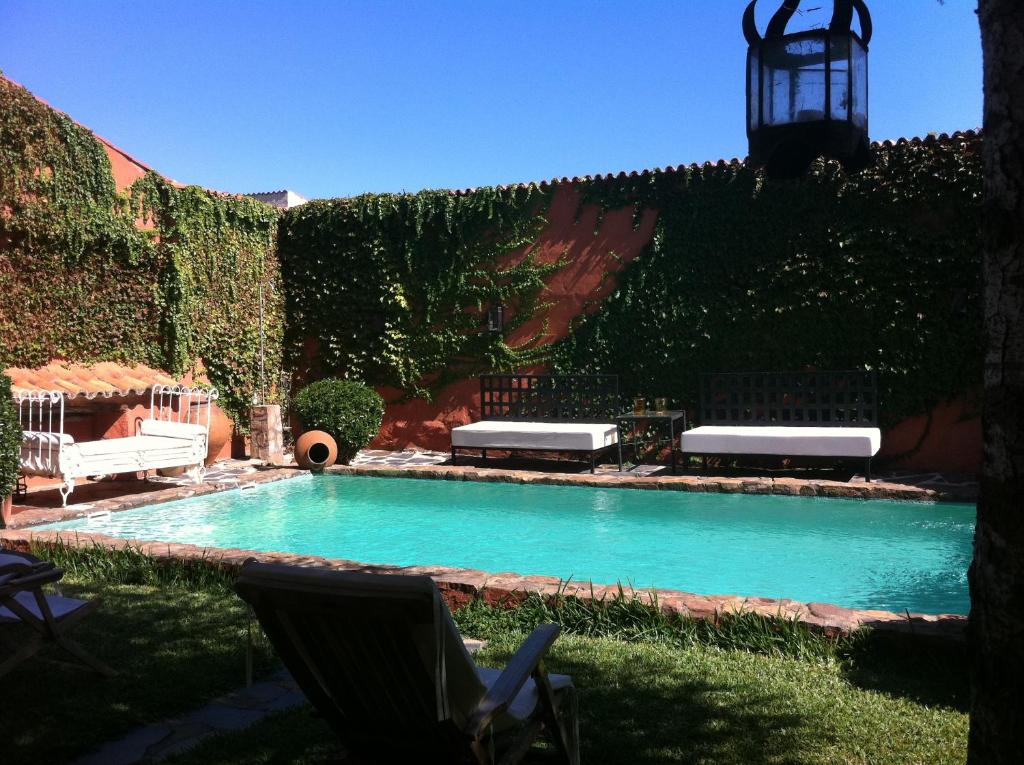 a swimming pool in a yard with a hedge at La Tierra Roja in Aliseda