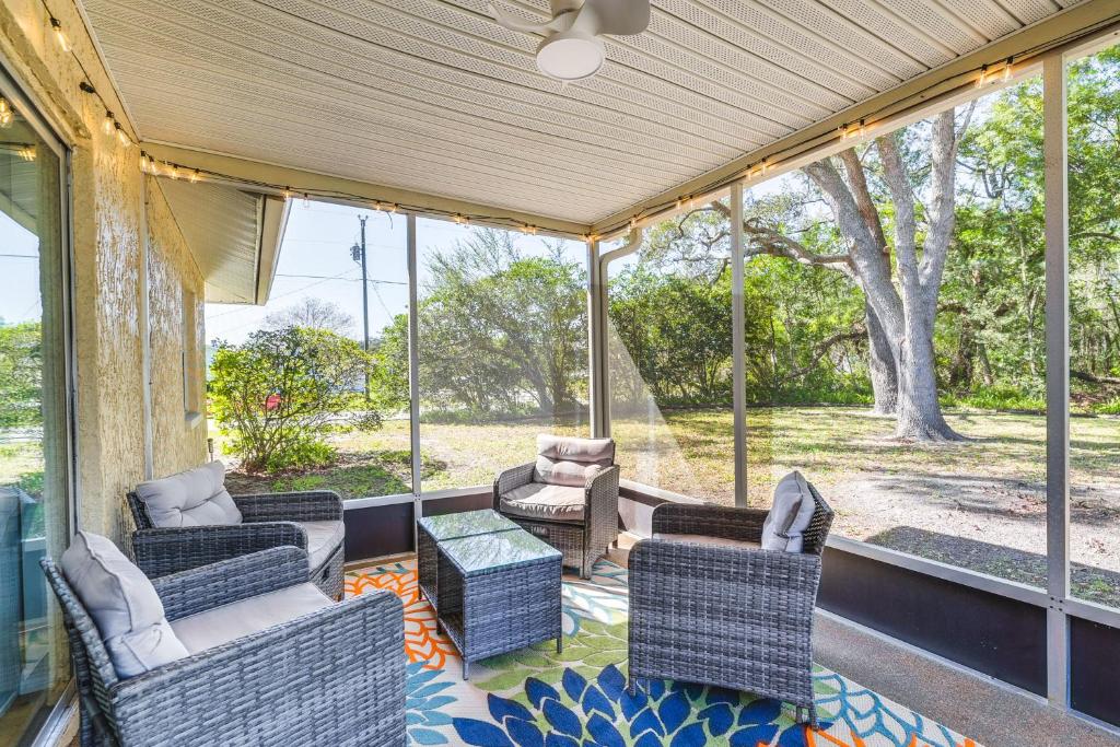 a screened in porch with chairs and a table at Home with Screened Porch, Near Weeki Wachee Springs! in Spring Hill