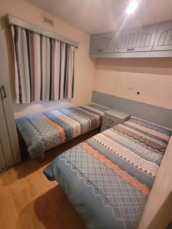 une chambre avec trois lits dans une pièce dans l'établissement Mobil home Gassin, à Gassin