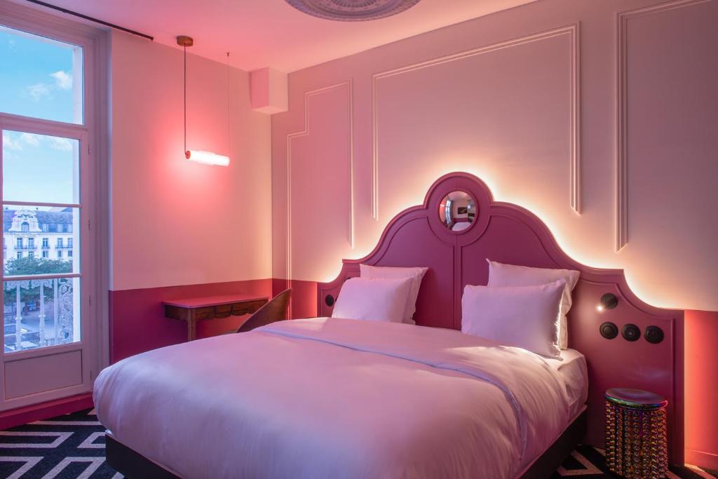 a bedroom with a large white bed with a headboard at LABE Hôtel Tours Centre Gare in Tours